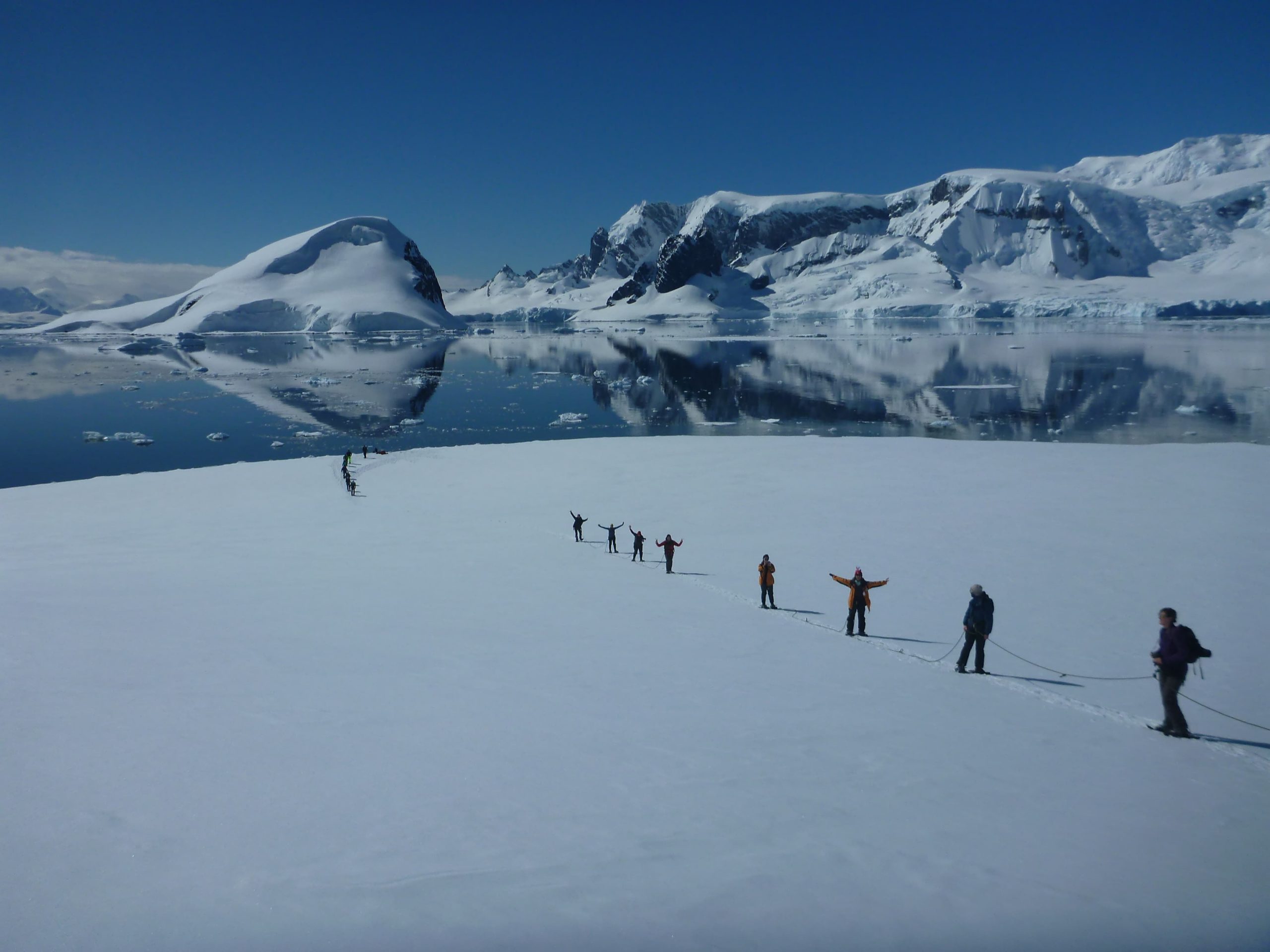 Antarctic mountaineers pose on a snow field
