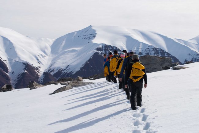 Antarctic mountaineers hike in line