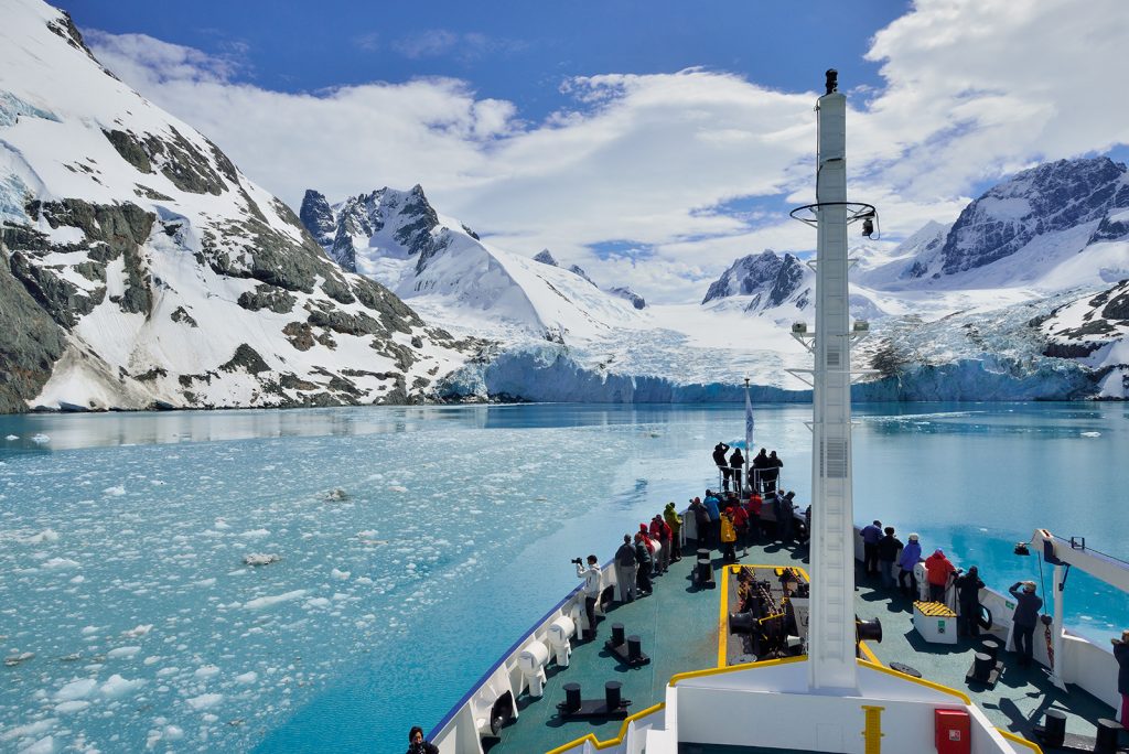 Antarctic cruise travelers watch the coastline