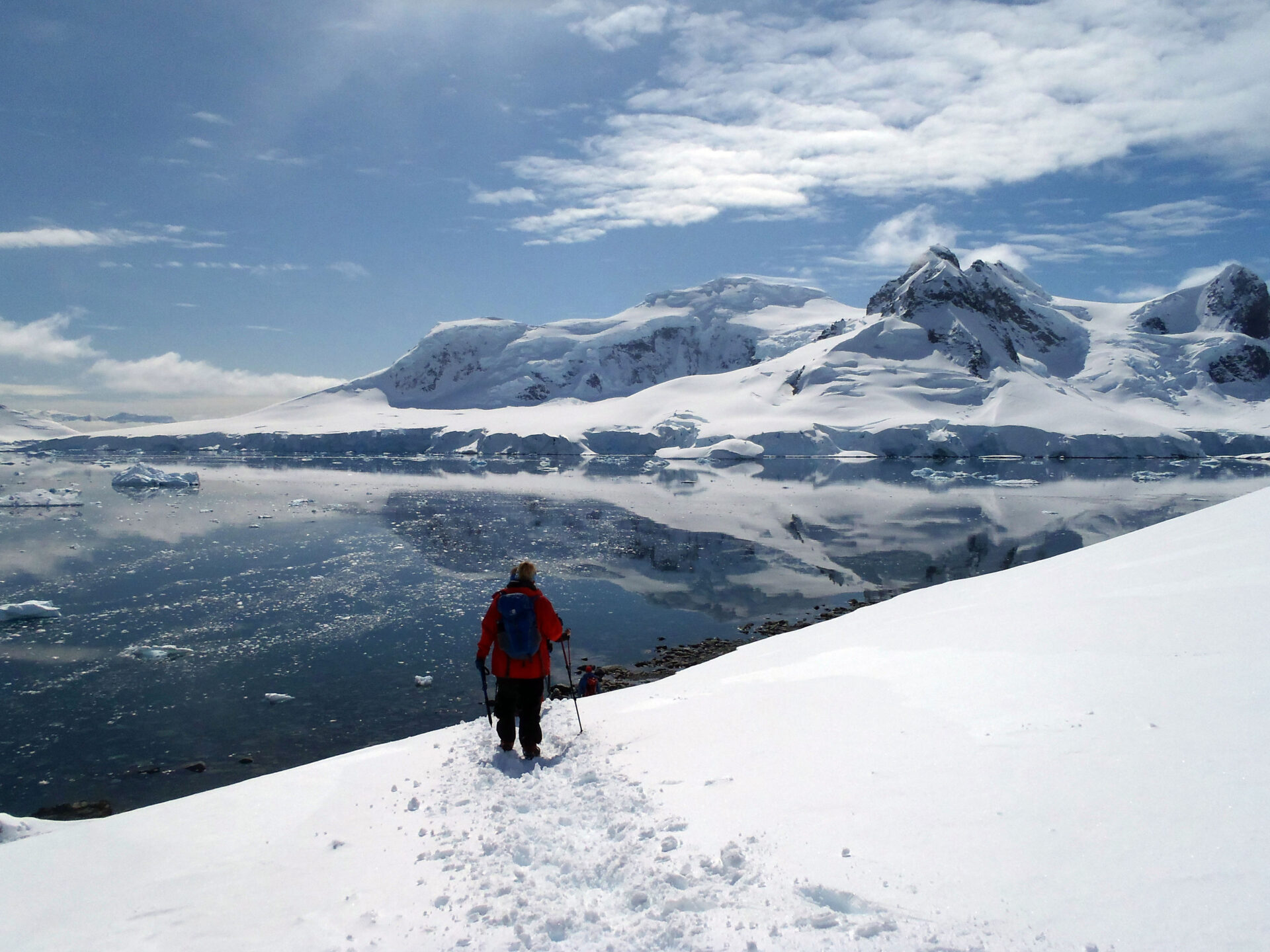 a tourist stands at the shores of antarctica cruises in march